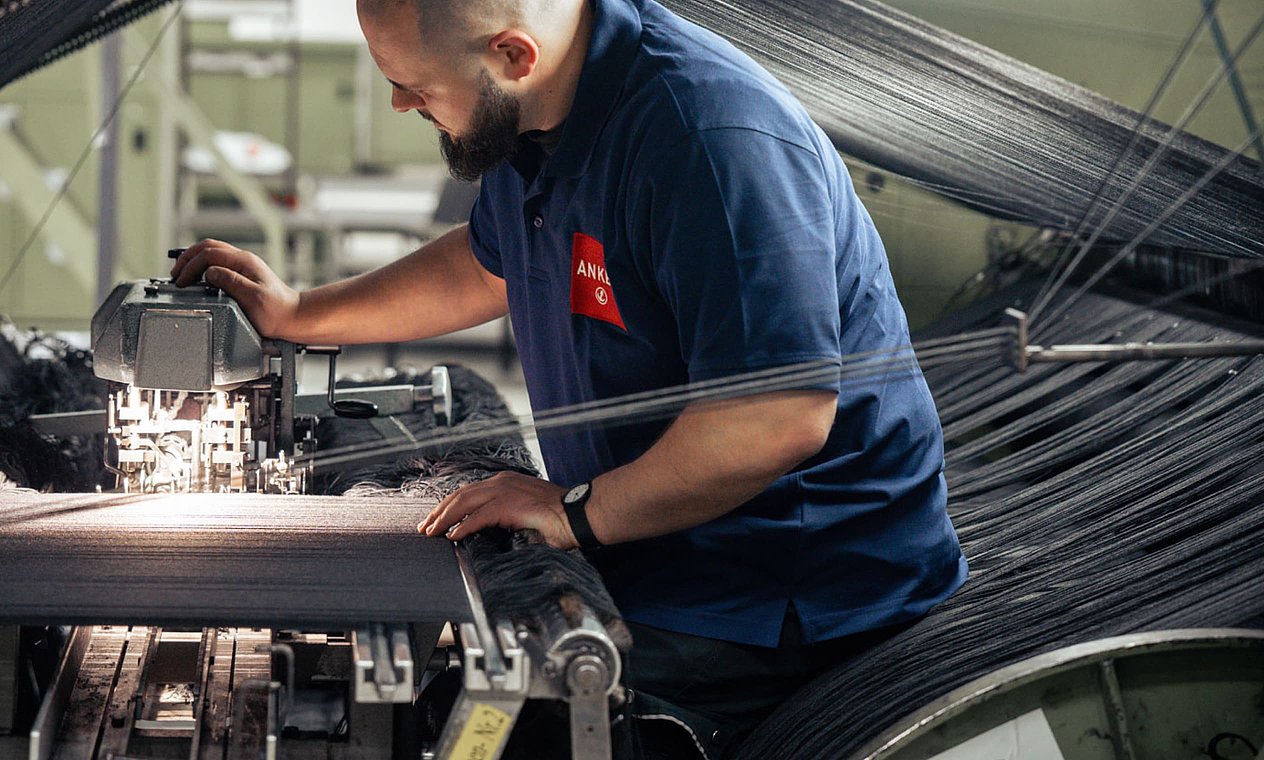 Arbeiter an Webmaschine